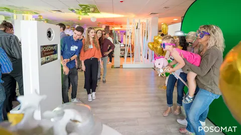 Guests in front of a green screen, next to them the POSOMAT photo booth