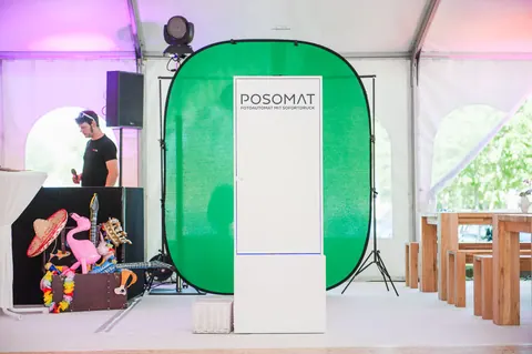 POSOMAT photo booth in front of a green screen background