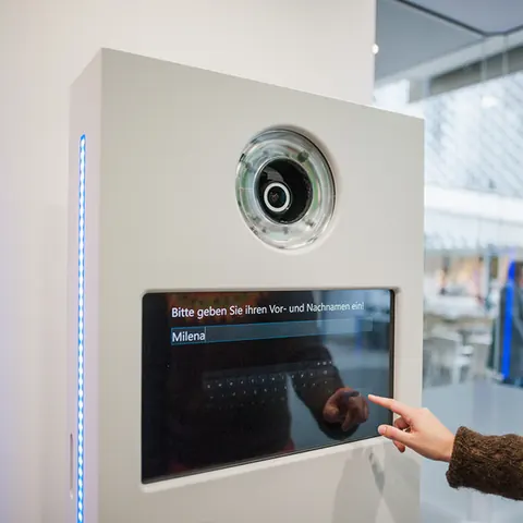 Guest using the touchscreen of a POSOMAT photo booth for a survey