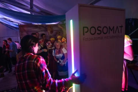 Guests in front of a POSOMAT L3000 with a glowing RGB LED strip at a party