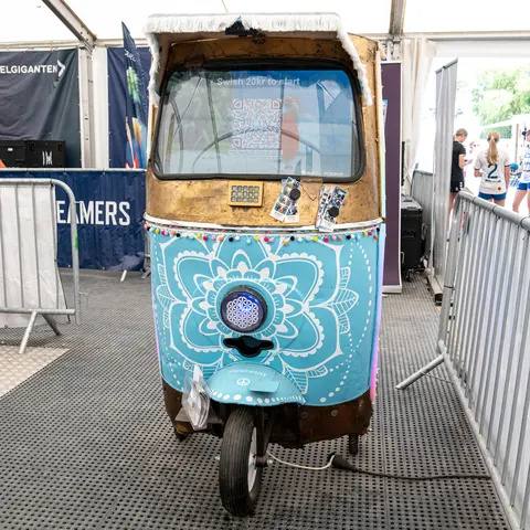 Colourfully painted vintage tuk tuk converted into a POSOMAT AR photo booth, with a screen in the windscreen